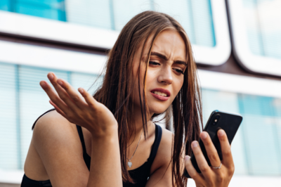Junge Frau ärgert sich über etwas auf dem Handy