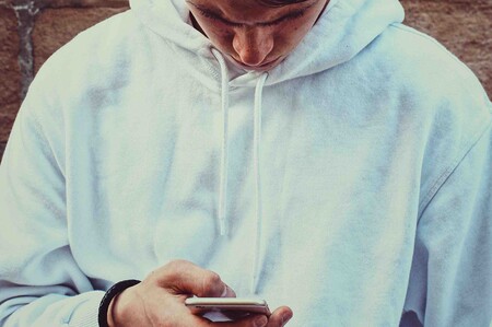 In der Corona-Zeit neigen wir zu übermäßigem Medienkonsum Junger Mann schaut traurig auf Smartphone