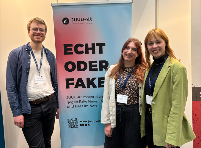 drei Personen am Messestand
