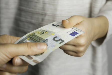 Ein Junge bekommt 5 Euro Schein von einem Mann
