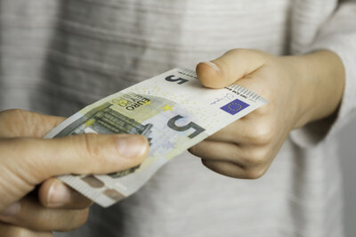 Taschengeld-Treffen Ein Junge bekommt 5 Euro Schein von einem Mann