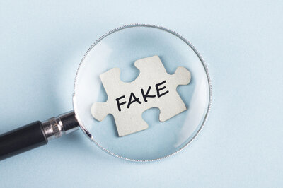 Lupe zeigt auf Puzzleteil, auf dem "Fake" steht
