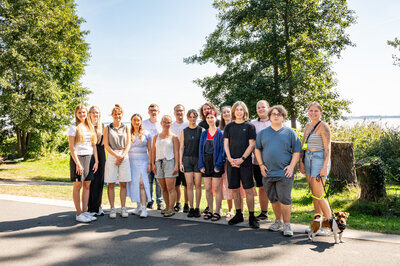 Eine Gruppe von Jugendlichen steht am Waldrand und schaut in die Kamera.
