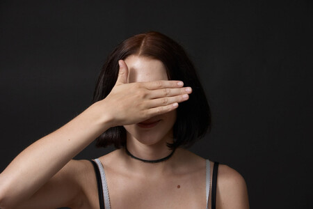 Eine Frau hält sich die Hand vor die Augen.