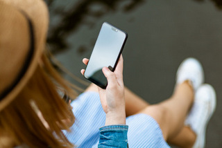 Handy reinigen und Corona-Infektion vermeiden Junge Frau hält Handy in der Hand