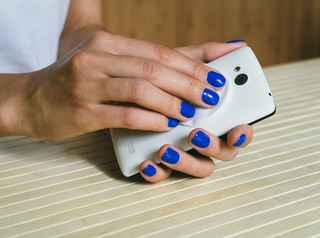 Smartphone reinigen und desinfizieren Frau reinigt Smartphone mit Wattepad