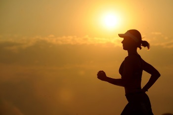 Eine Frau joggt vor Sonnenuntergang